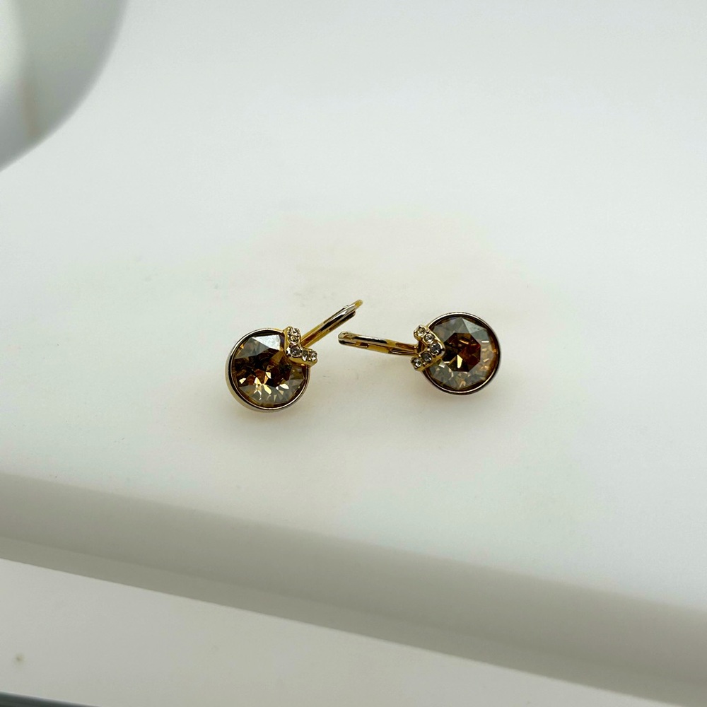 Swarovski lever back earrings. Crystal is a champagne color. Gold plated.